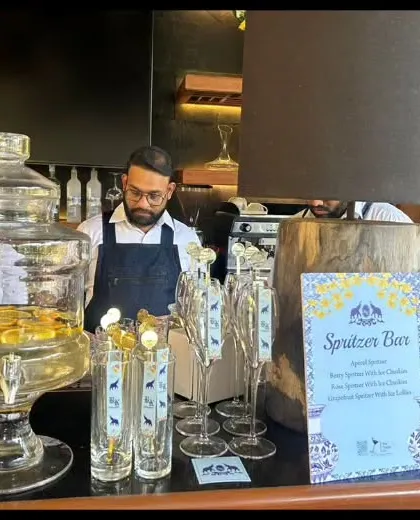 A dedicated Spritzer Bar set up for an intimate gathering. We provide large glass dispensers of pre-mixed spritzers and a variety of fresh fruit garnishes for guests to customize their drinks.