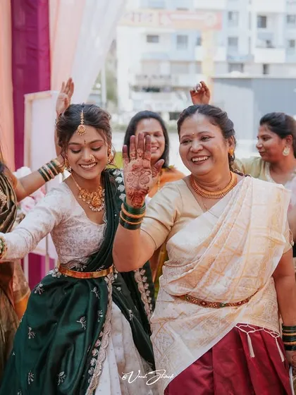 The bride and her family dancing with joy, their hands decorated with henna, during the Haldi celebrations.