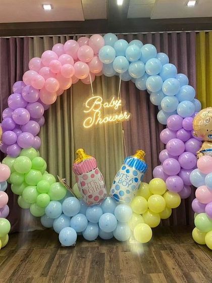 This pastel baby shower ring includes cute baby-shaped foil balloons, adding a playful touch to the decor.