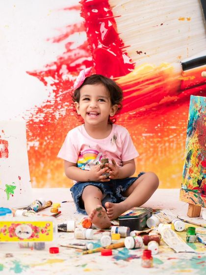 A happy artist. This little girl's bright smile shows just how much fun a messy, creative photoshoot can be.