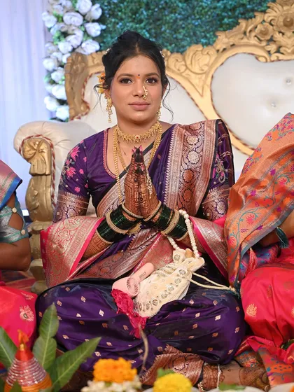 A beautiful bride ready for her Vidhi ceremony in a stunning purple Paithani saree. The makeup is soft and romantic, with a focus on her expressive eyes.