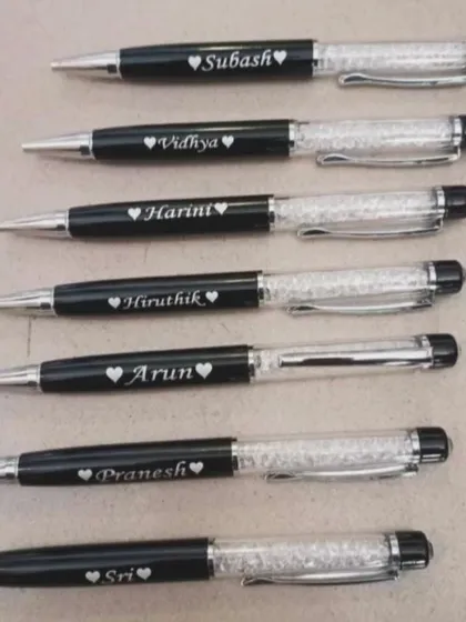 A batch of personalized crystal pens, each engraved with a name and a small heart. These make for beautiful and elegant gifts.