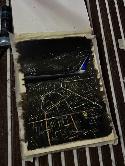 The painting in progress. I used a lot of black paint to create the night sky and then carefully added the glowing city grid.