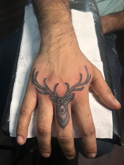 A minimalist deer head tattoo on the finger. This is a very unique and subtle way to carry the symbol of gentleness and grace.