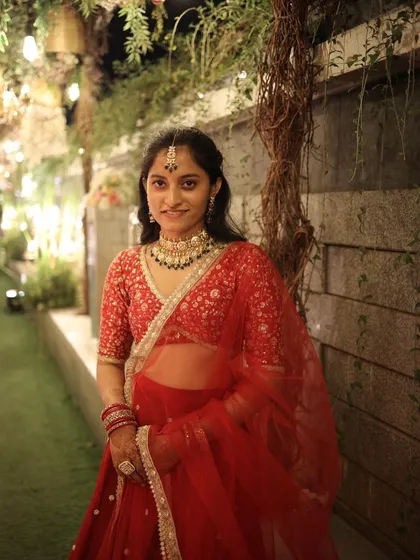 A closer look at the head-to-toe styling for this wedding guest. We paired the red lehenga with a traditional necklace and maang tikka to complete her beautiful ethnic look.