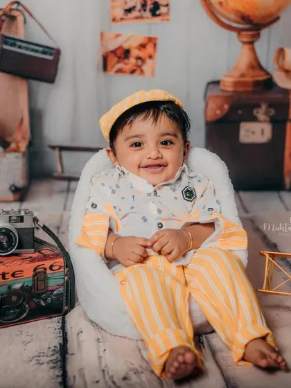 This little explorer is ready to see the world. The vintage travel props create a wonderful sense of nostalgia and adventure.