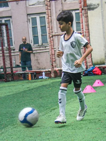 A player moves with the ball during an indoor session, demonstrating the adaptability of our training across different environments.