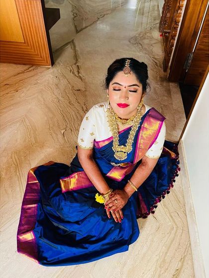 Dolled up my dearest client for her bangle ceremony at home. This look features a classic South Indian hairstyle with a traditional braid, paired with glowing skin and a bold red lip that stands out against her royal blue silk saree.