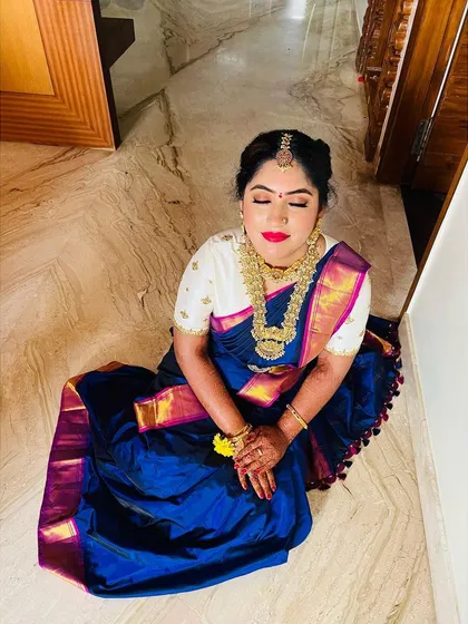 A moment of calm for the bride. The overhead shot showcases the beautiful eye makeup and the richness of her blue silk saree.