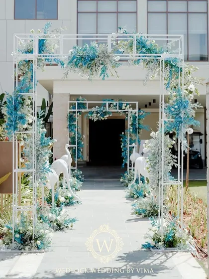 Welcome to paradise. For this brunch pool party, we designed a stunning floral archway flanked by white flamingo statues to set a chic, tropical tone right from the entrance.