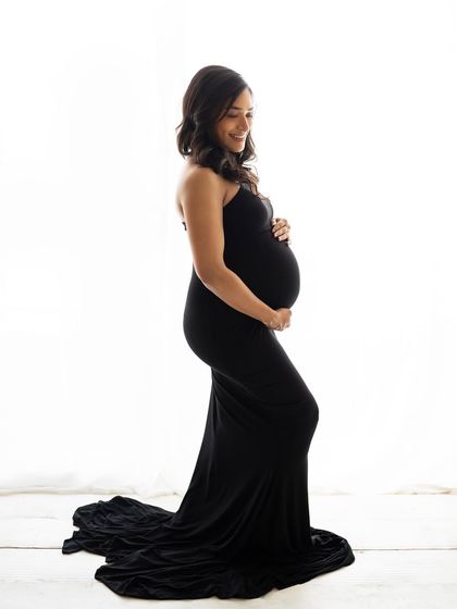 A smiling portrait of the mom-to-be in her elegant black gown. The simplicity of the shot allows her joy and beauty to be the complete focus.