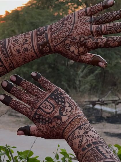 A detailed bridal design captured outdoors at sunset, with the warm light enhancing the henna's rich tones.