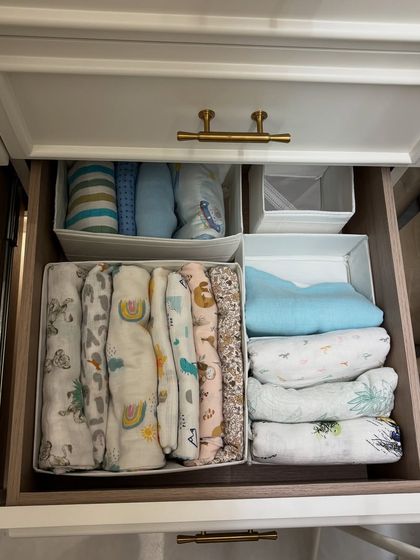 A drawer dedicated to baby swaddles and blankets, neatly folded and categorized for easy access.