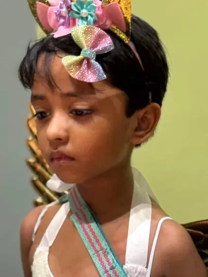 A lovely unicorn with a rainbow headband, looking thoughtful during the Halloween festivities.