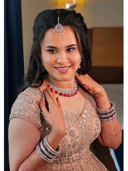 A beautiful smile from this bride at her reception. Her makeup is soft and radiant, with a lovely pink lehenga and diamond jewelry.