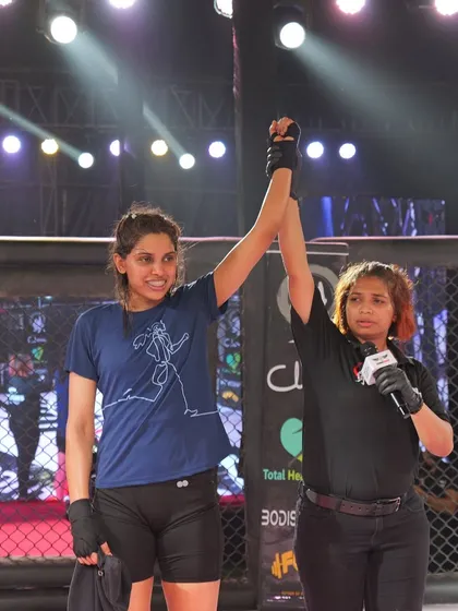 The referee raises Kiran's hand in victory after a skilled performance at ACS 9.