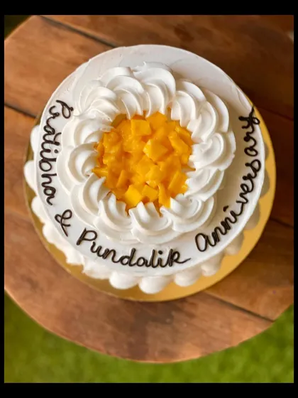 An anniversary cake in my seasonal mango flavor, decorated with fresh mango chunks in the center.