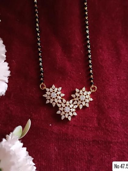 A lovely floral-inspired mangalsutra, this design features three interconnected flowers made of American diamonds. It's a feminine and graceful piece for everyday wear.