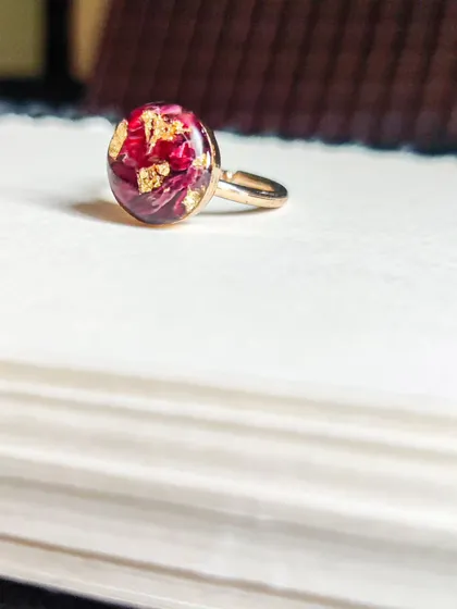 A beautiful ring made with preserved rose petals and gold flakes. This adjustable ring is a delicate and romantic way to keep a special flower close to you always.