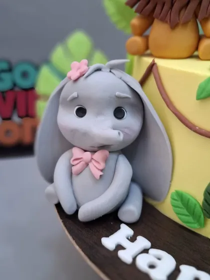 A close-up of the sweet elephant with a pink bow.