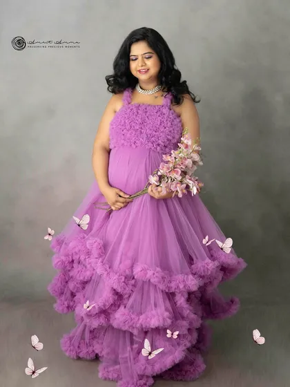 The addition of delicate butterflies adds a touch of whimsy and magic to this already stunning portrait in the purple ruffled gown.