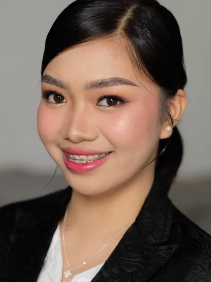 A clean and professional corporate makeup look. The makeup is minimal and fresh, with a focus on even skin, defined brows, and a pop of color on the lips to look polished and confident.