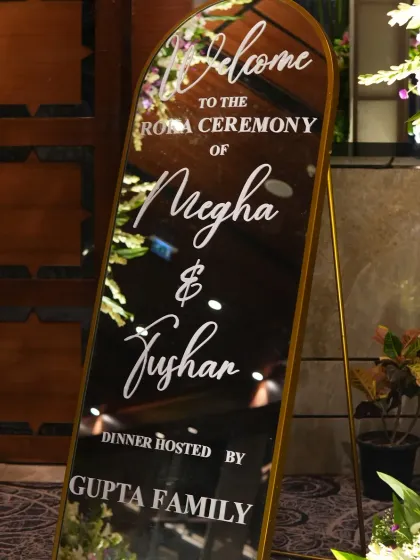 A close-up of the elegant, mirrored welcome sign for Megha and Tushar's Roka ceremony.