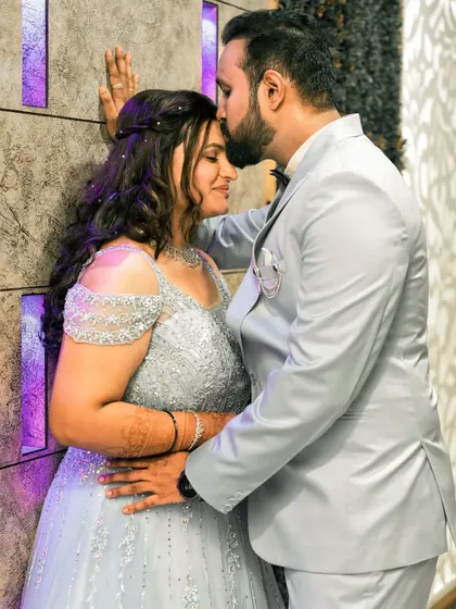 A tender forehead kiss, capturing the intimacy and affection between the couple during their engagement celebration.