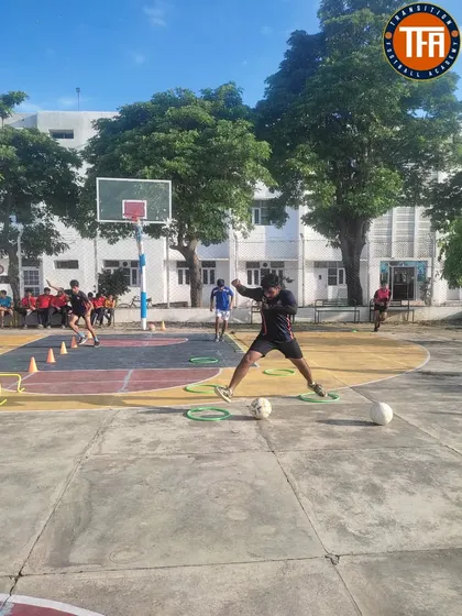 A player works on close-control dribbling through a series of rings and cones, a drill designed to enhance technical ability in tight spaces.