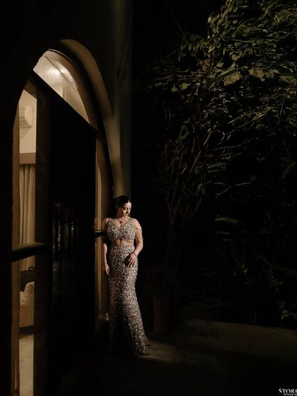 The bride standing in a doorway at night, her shimmering gown catching the light. This shot has a mysterious and cinematic feel.