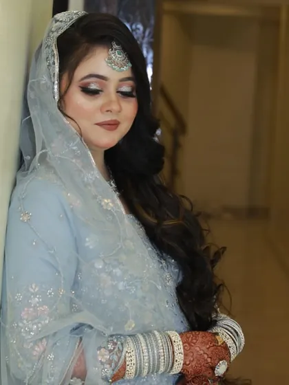 A beautiful portrait of a bride in a powder blue outfit. The makeup is soft and glowing.