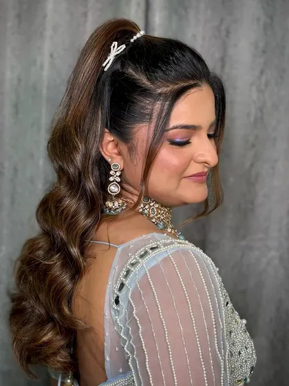 A side profile of the Bandoli look, showcasing the high ponytail hairstyle and the soft, shimmery makeup.