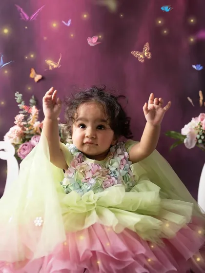 Reaching for the magic. This candid shot captures her sense of wonder as she looks up at the fluttering butterflies during her enchanted garden photoshoot.