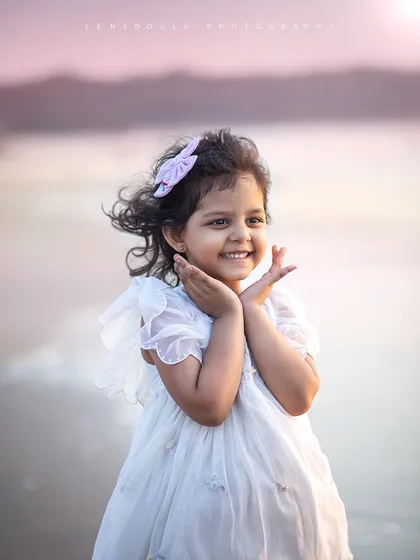 What a sweet and expressive portrait of this little girl on the beach. Her happy smile and the soft sunset light make this photo truly special.