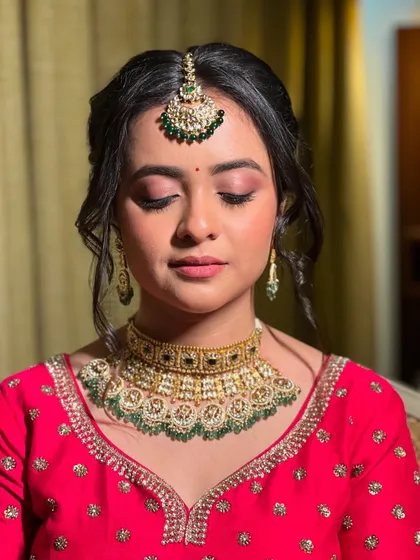 A close-up portrait focusing on the beautiful eye makeup and the traditional green and gold jewellery.