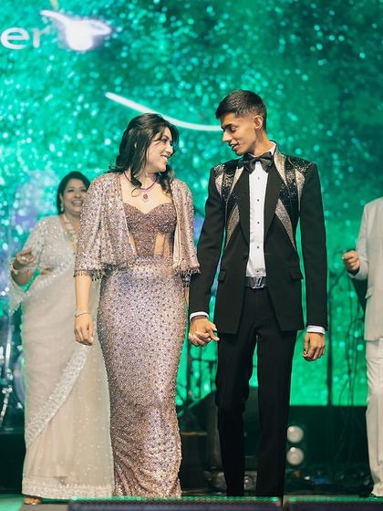 A beautiful moment between a brother and sister, surrounded by their proud family on stage.