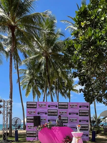 A wide shot of the Phuket beach party setup. The location was absolutely perfect, with tall palm trees and a view of the ocean.