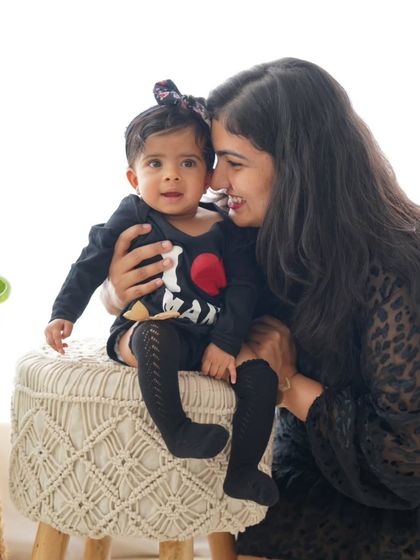 A sweet and interactive moment between mother and daughter on a rustic macrame stool.