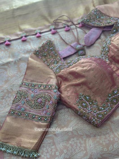 A dusty pink blouse with intricate paisley embroidery on the sleeves.