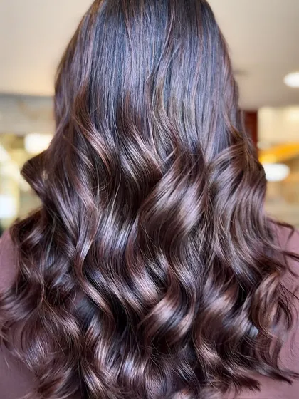 This image showcases a beautiful blend of caramel and brown tones. The soft waves highlight the different dimensions in the color, creating a look that is both hot and timeless.