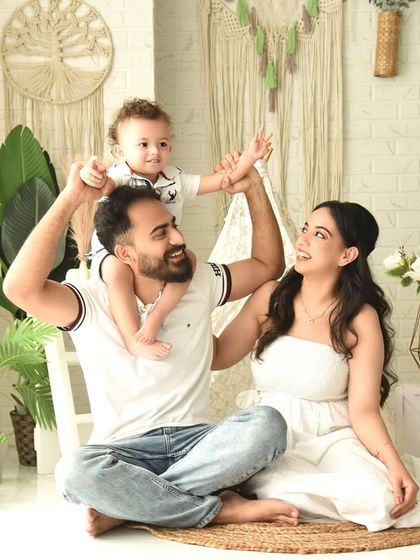 A playful family photo in our boho set, with the toddler sitting on dad's shoulders and reaching for the macrame wall hanging. This captures the curious and fun-loving nature of childhood.