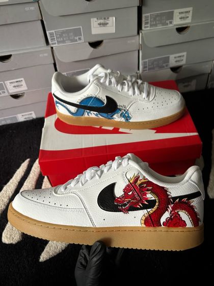 The full pair of dragon-themed sneakers, with a red dragon on one shoe and a blue one on the other.