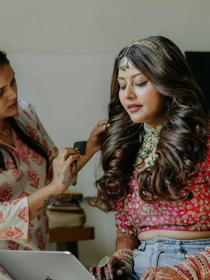 Here I am, adding the final touches to a bride's soft, voluminous curls for her wedding day. This behind the scenes moment captures the focus and care I put into ensuring every single strand is perfect for the final look.