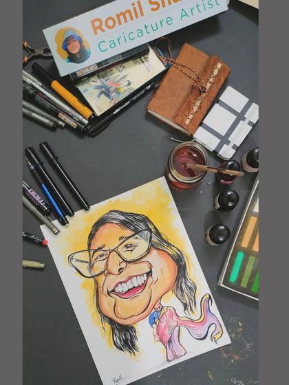 The colored version of the super-woman caricature, shown on my desk with my art supplies. You can see how a splash of color and pastels brings the character to life.