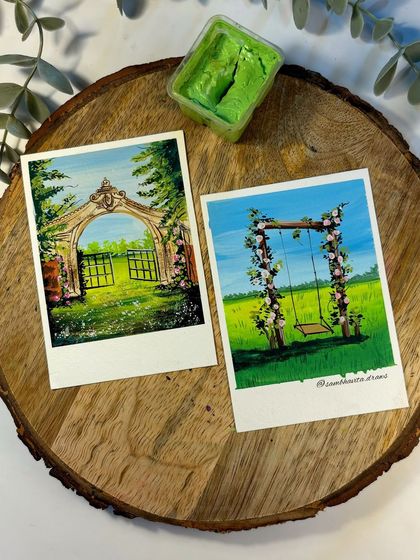 A couple of my favorite polaroid paintings, featuring a floral swing in a field and a whimsical garden gate. These gouache scenes are inspired by cottagecore aesthetics and bring a touch of dreamy nature to your space.