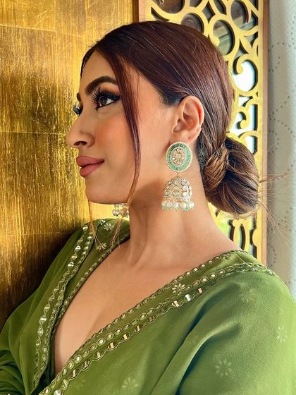 Sometimes, a pair of earrings can do what a beautiful outfit cannot. This stunning pair of mint green jhumkas with intricate silver work is designed to be the centerpiece of your look.