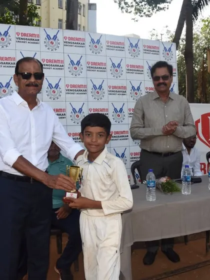 A player receiving his trophy for his excellent performance in the Dream11 Cup.