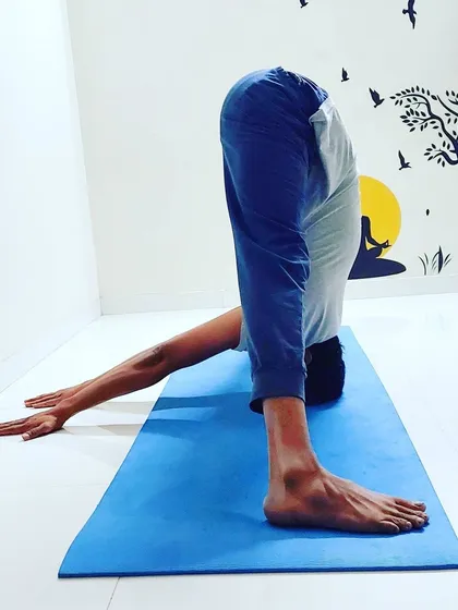 Here I am in Prasarita Padottanasana, a wide-legged forward bend that lengthens the spine and stretches the hamstrings. I often prescribe this asana for clients experiencing mild backache, as it helps to decompress the vertebrae and calm the nervous system.