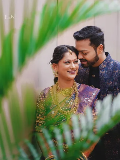A sweet, candid moment captured through foliage. This creative framing adds a layer of intimacy to this beautiful couple's portrait.