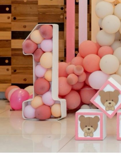 A balloon-filled number '1' prop next to cute, custom-made teddy bear blocks, perfect for a first birthday.